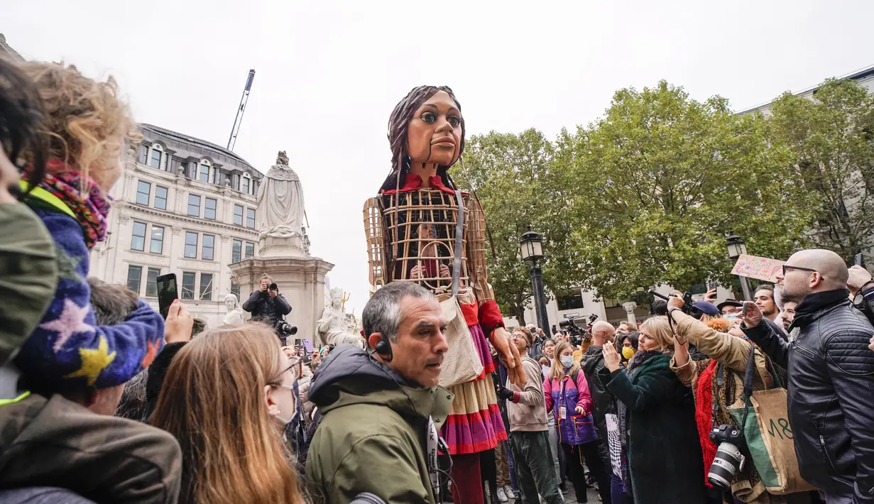 Boneka raksasa Little Amal tiba di Katedral St Paul, di London, Inggris, Sabtu (23/10/2021). Little Amal akan melanjutkan perjalanan ke kota Manchester di kawasan Inggris yang akan menjadi pemberhentian terakhirnya. (AP Photo/Alberto Pezzali)