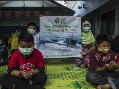 Siswa dan guru berdoa untuk 53 awak kapal selam KRI Nanggala 402 yang hilang di perairan Bali, di sebuah sekolah Islam di Surabaya, Jumat (24/4/2021). Kapal selam KRI Nanggala-402 yang membawa 53 awak dilaporkan hilang kontak di perairan Bali, Rabu, 21 April kemarin. (Juni Kriswanto/AFP)