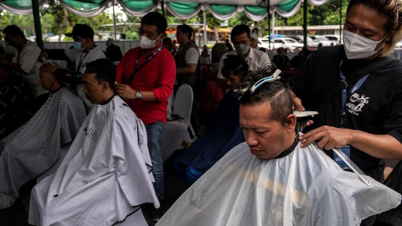Masyarakat mengikuti potong rambut massal dalam rangka menyambut bulan suci Ramadan di Masjid Al Akbar Surabaya pada 11 Maret 2024. Foto: AFP / Juni Kriswanto