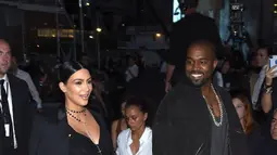 Kim Kardashian ditemani suaminya, Kanye West saat tiba untuk menghadiri Givenchy Spring/Summer 2016 pada acara New York Fashion Week di New York, Jumat (11/9/2015). (Larry Busacca/Getty Images/AFP)