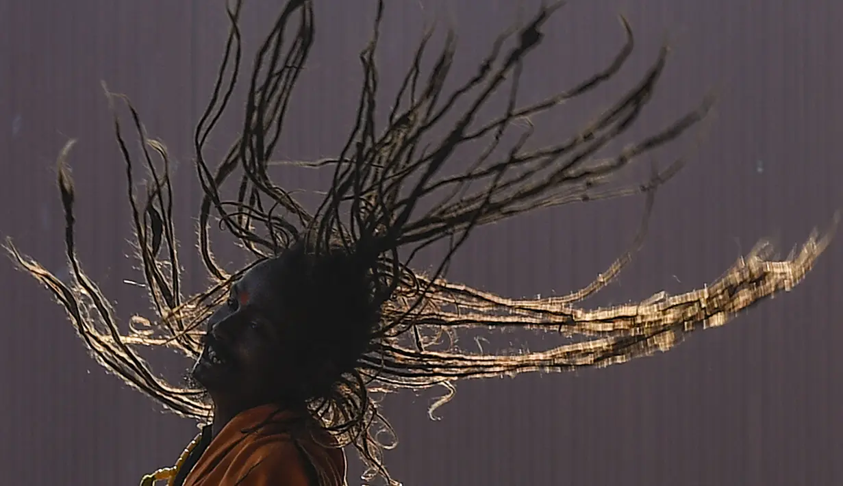 Seorang Sadhu atau orang suci Hindu mengibaskan rambutnya menjelang festival Hindu 'Maha Shivaratri', di Kathmandu (9/3/2021). (AFP/Prakash Mathema)