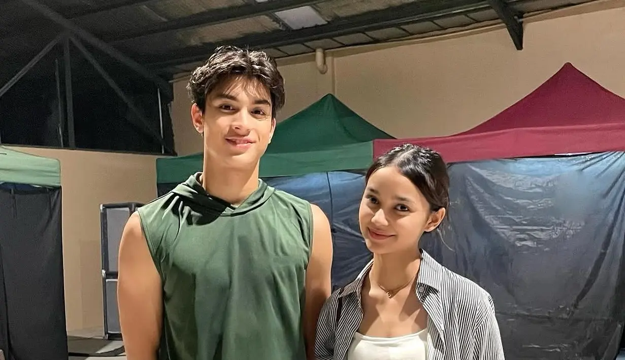 Dalam foto yang diunggah, Sydney Azkassyah dan Eddie Meijer terlihat berdiri berdampingan dengan senyum ramah. Eddie tampil kasual dengan kaos tanpa lengan hijau dan celana pendek putih, sementara Sydney memadukan tank top putih dengan kemeja motif garis serta celana jeans. Kedekatan artis muda ini semakin mencuri perhatian karena mereka tampak nyaman saat berpose bersama.  (Liputan6.com/IG/@cuttaryofficial)