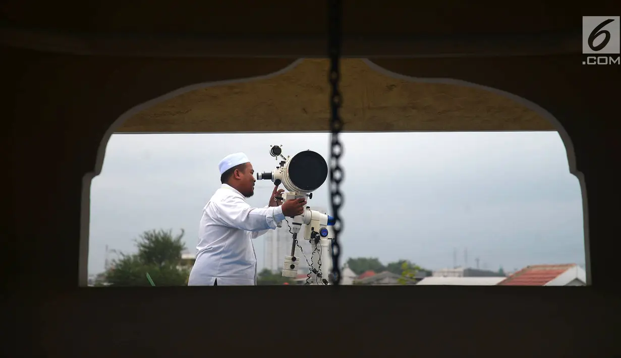 Petugas meneropong posisi hilal (bulan) dari Pondok Pesanteren Al-Hidayah Jakarta, Selasa (15/5). Pemantauan hilal ini dilakukan untuk menentukan jatuhnya 1 Ramadan 1439 H. (Merdeka.com/Imam Buhori)