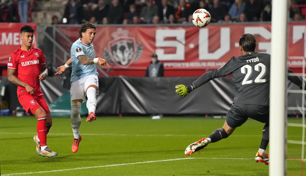 Pemain Twente, Mees Hilgers (kiri) membayangi pemain Lazio, Luca Pellegrini saat melepaskan tembakan ke gawang timnya dalam laga lanjutan Liga Europa 2024/2025 yang berlangsung di De Grolsch Veste stadium, Enschede, Belanda, Jumat (25/10/2025) dini hari WIB. (AP Photo/Peter Dejong)