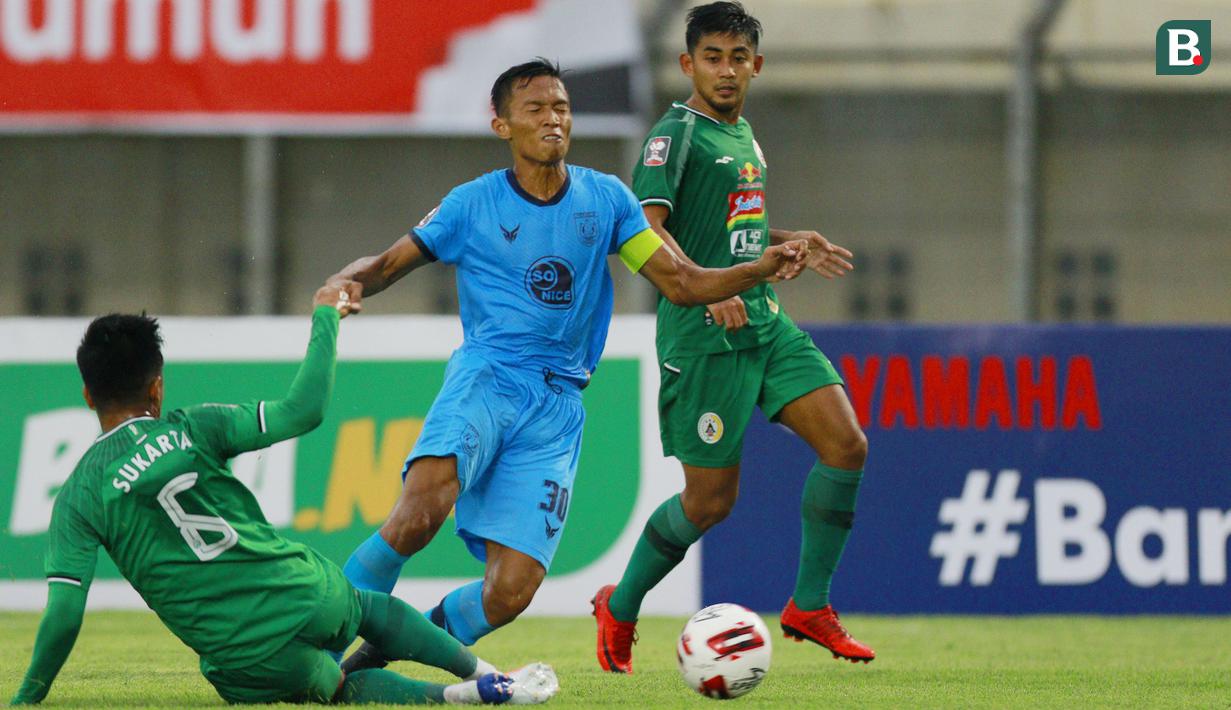 Pemain Persela Lamongan, Eky Taufik (tengah) terjatuh saat berebut bola dengan pemain PSS Sleman, Wahyu Sukarta dalam laga matchday ke-2 Grup C Piala Menpora 2021 di Stadion Si Jalak Harupat, Bandung, Minggu (28/3/2021). Persela bermain imbang 0-0 dengan PSS Sleman. (Bola.com/M Iqbal Ichsan)