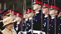 Ratu Elizabeth II memeriksa Sovereign's Parade di Royal Military Academy pada 12 April 2006. Pangeran Harry yang berada di barisan (prajurit di tengah) tersenyum di hadapan sang nenek. (AP Photo/Dylan Martinez, pool)