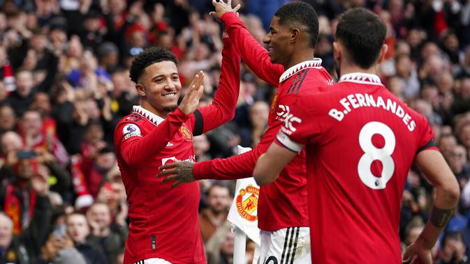 <p>Jadon Sancho, Marcus Rashford, dan Bruno Fernandes melakukan selebrasi setelah merobek gawang Leicester City dalam lanjutan Liga Inggris 2022/2023 di Old Trafford, Minggu (19/2/2023) malam WIB. (AP Photo/Dave Thompson)</p>