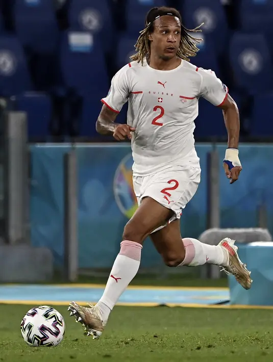 Bek Swiss, Kevin Mbabu membawa bola saat bertanding melawan Italia pada pertandingan grup A Euro 2020 di stadion Olimpiade di Roma, Italia, Rabu (16/6/2021). Dengan hasil ini, Italia kokoh dipuncak klasemen dengan poin enam. (Andreas Solaro/Pool Photo via AP)