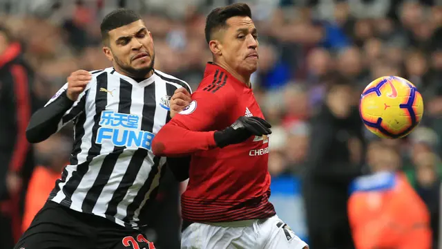 Gelandang Manchester United, Alexis Sanchez, berebut bola dengan bek Newcastle, DeAndre Yedlin, pada laga Premier League di Stadion St James Park, Newcastle, Rabu (2/1). Newcastle kalah 0-2 dari MU. (AFP/Lindsey Parnaby)