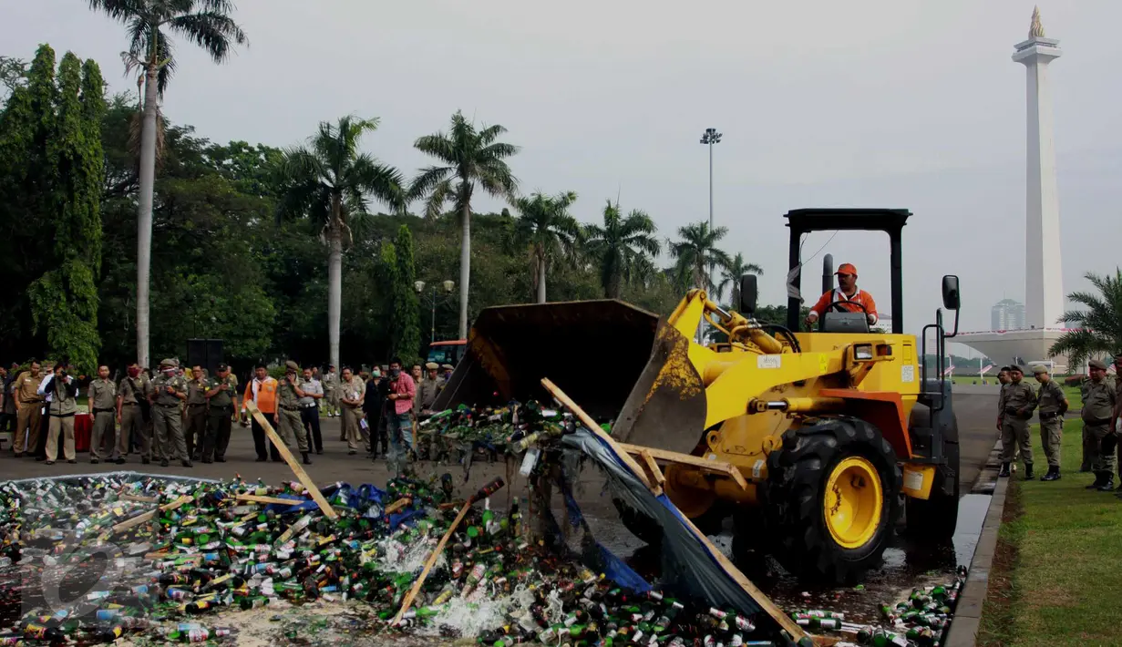 Operator alat berat memusnahkan ribuan botol minuman beralkohol ilegal hasil penertiban Januari-Juni 2016, di kawasan Monas, Jakarta, Selasa (28/6). Sebanyak 19.628 botol yang antara lain hasil penertiban di kawasan Kalijodo. (Liptan6.com/Gempur M Surya)