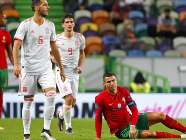 Striker Portugal, Cristiano Ronaldo, terduduk lesu di lapangan saat melawan Spanyol pada laga uji coba di Stadion Jose Alvalede, Kamis (8/10/2020). Kedua tim bermain imbang 0-0. (AP Photo/Armando Franca)