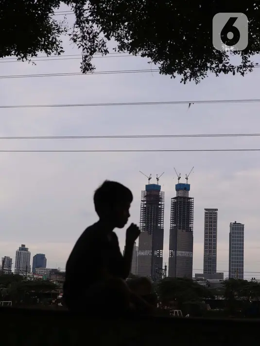 Seorang melihat gedung bertingkat di Jakarta, Sabtu (19/3/2022). Bank Indonesia (BI) memperkirakan pertumbuhan ekonomi Indonesia akan meningkat lebih tinggi, pada kisaran 4,7 persen hingga 5,5 persen, dari pertumbuhan 3,69 persen pada 2021. (Liputan6.com/Angga Yuniar)