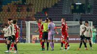 Para pemain Persis Solo memprotes kartu merah yang didapatkan oleh bek asing, Cleylton Santos, yang dikeluarkan oleh wasit Irfan Wahyu Wijanarko pada pertandingan melawan PSM Makassar di Stadion Manahan, Solo, Senin (13/1/2025) malam WIB. (Bola.com/Radifa Arsa)