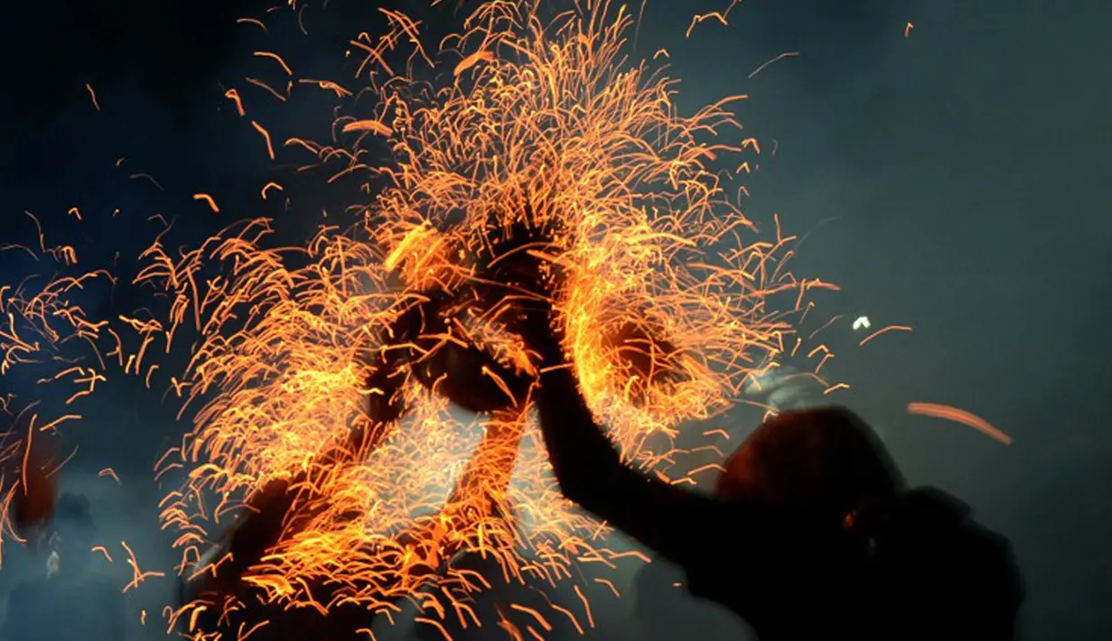 Pemuda Bali menggelar tradisi siat geni atau perang api di Pura Dalam, Tuban, Senin (28/9/2015) malam. Ritual ini diselenggarakan setiap tahun untuk melestarikan tradisi sekaligus memohon keselamatan dan menolak bala. (AFP/Sonny Tumbelaka)