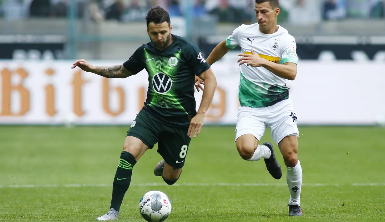Gelandang Wolfsburg, Renato Steffen, berebut bola dengan bek Borussia Monchengladbach, Stefan Lainer, pada laga lanjutan Bundesliga di Borussia Park Stadium, Rabu (17/6/2020) dini hari WIB. Monchengladbach menang telak 3-0 atas Wolfsburg. (AFP/Thilo Schmuelgen/pool)