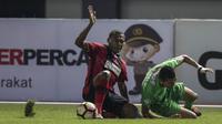Bek Persipura, Yustinus Pae, menjatuhkan striker Bhayangkara FC, Dendy Sulityawan, pada laga Liga 1 Indonesia di Stadion Patriot, Bekasi, Sabtu (9/9/2017). Bhayangkara FC menang 2-1 atas Persipura. (Bola.com/Vitalis Yogi Trisna)