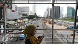 Pejalan kaki berjalan di halte Transjakarta di Jalan Sudirman, Jakarta, Senin (2/5). Mulai tahun ini, Pemprov DKI Jakarta akan menata jalan, trotoar, dan taman di kawasan Sudirman-Thamrin. (Liputan6.com/Immanuel Antonius)