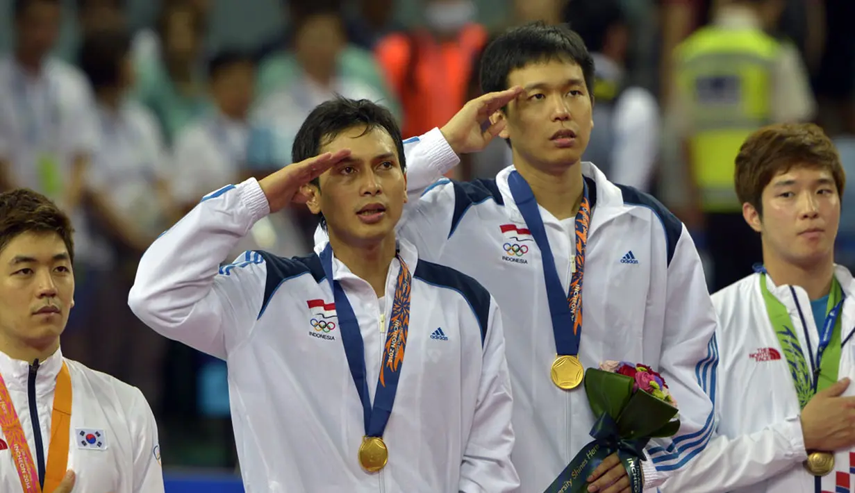 Muhamad Ahsan dan Hendra Setiawan memberi hormat sambil menyanyikan lagu Indonesia Raya di Gyeyang Gymnasium, Korsel, (28/9/2014). (ANTARA FOTO/Saptono)