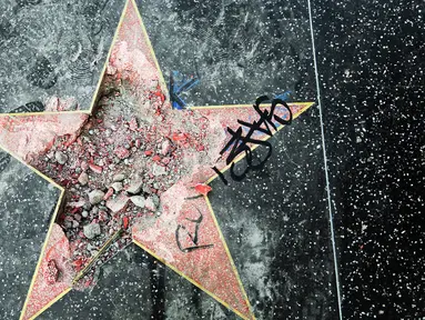 Bintang di Walk of Fame Hollywood atas nama Presiden Amerika Serikat (AS) Donald Trump yang rusak di Los Angeles, Rabu (25/7).  Perusakan Hollywood Walk of Fame Donald Trump itu dilakukan seorang pria menggunakan kapak dalam aksinya. (AP/Reed Saxon)