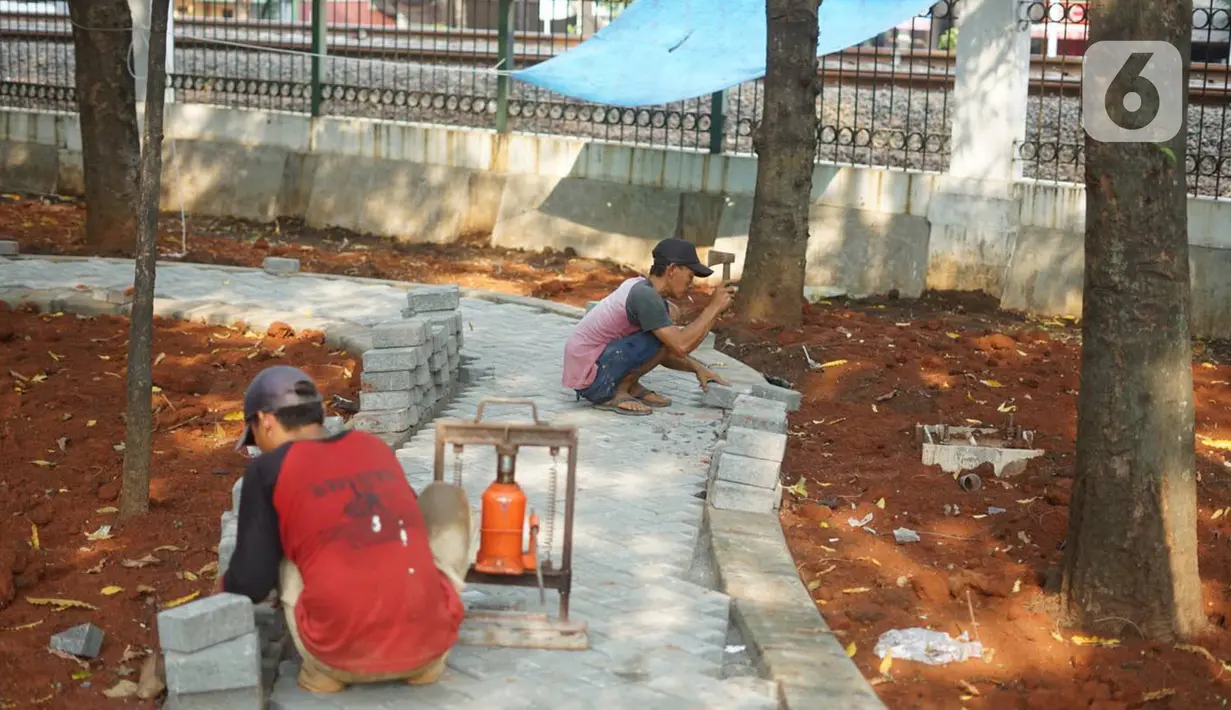 Pekerja menyelesaikan pembuatan jogging track di Taman Citra PPSU Srengseng Sawah, Jakarta, Rabu (4/12/2019). Jogging track tersebut dibuat guna meningkatkan kenyamanan bagi warga yang ingin beraktivitas di taman tersebut. (Liputan6.com/Immanuel Antonius)