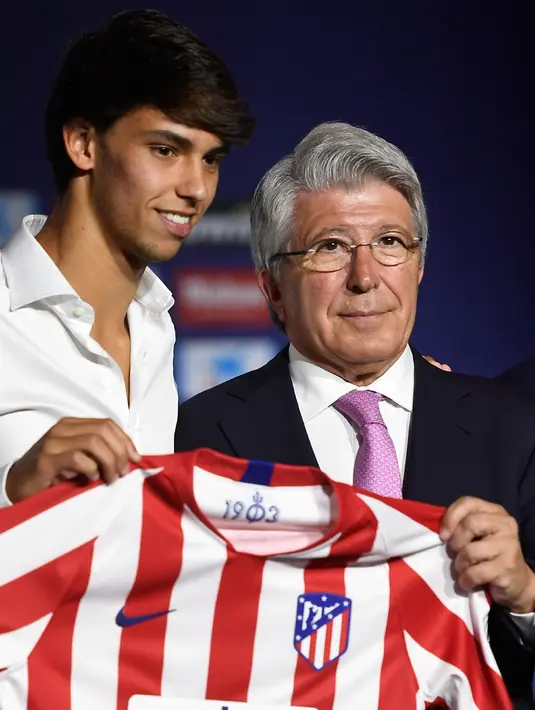 Gelandang baru Atletico Madrid, Joao Felix bersama presiden klub Enrique Cerezo berpose dengan jersey saat perkenalan dirinya di Stadion Wanda Metropolitano, Madrid (8/7/2019). Joao Felix diboyong Atletico klub Portugal, Benfica seharga 126 juta euro. (AFP Photo/Philippe Marcou)