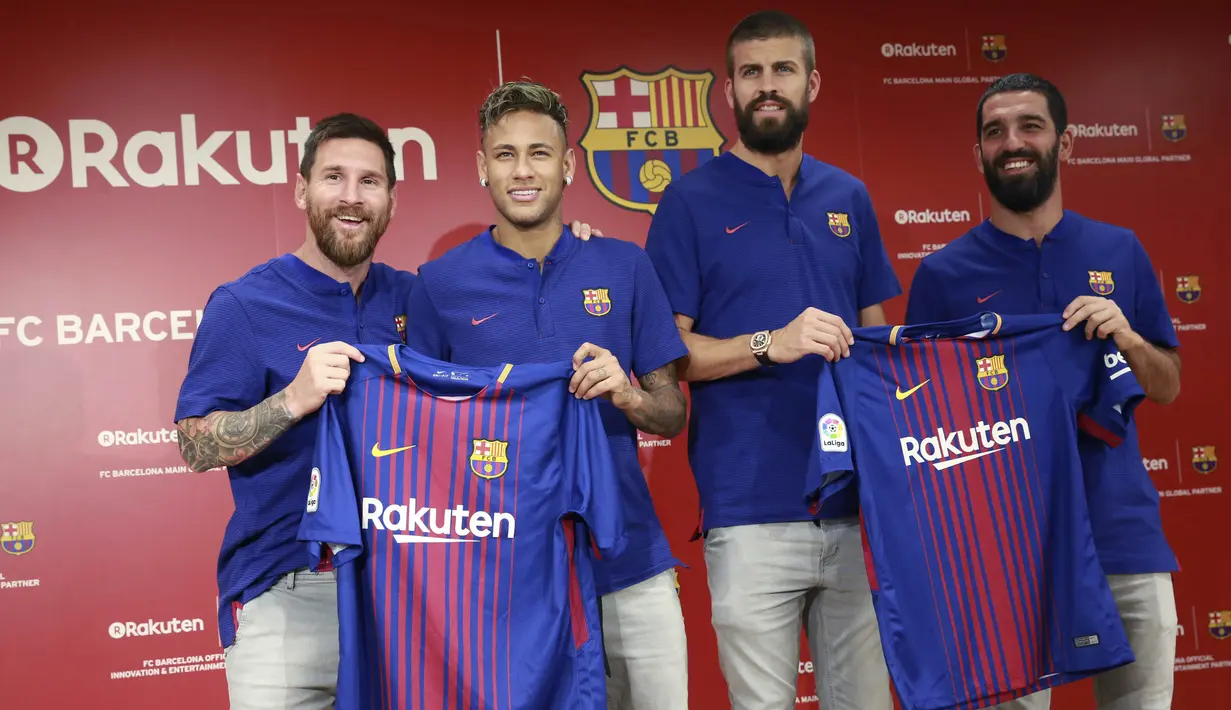 Pemain Barcelona, Lionel Messi, Neymar, Gerard Pique, dan Arda Turan menunjukan jersey baru La Blaugrana di Tokyo, Jepang (13/7/2017). Barcelona resmi merilis jersey baru dengan Rakuten sebagai sponsor utama musim ini. (AP/Eugene Hoshiko)