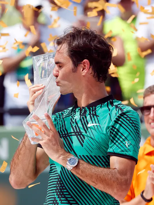 Petenis Swiss, Roger Federer mencium trofi usai memenangkan pertandingan pada final Miami Terbuka di Crandon Park, Florida (2/4). Federer menundukkan rival lamanya, Rafael Nadal dua set langsung 6-3, 6-4. (AP Photo/Wilfredo Lee)