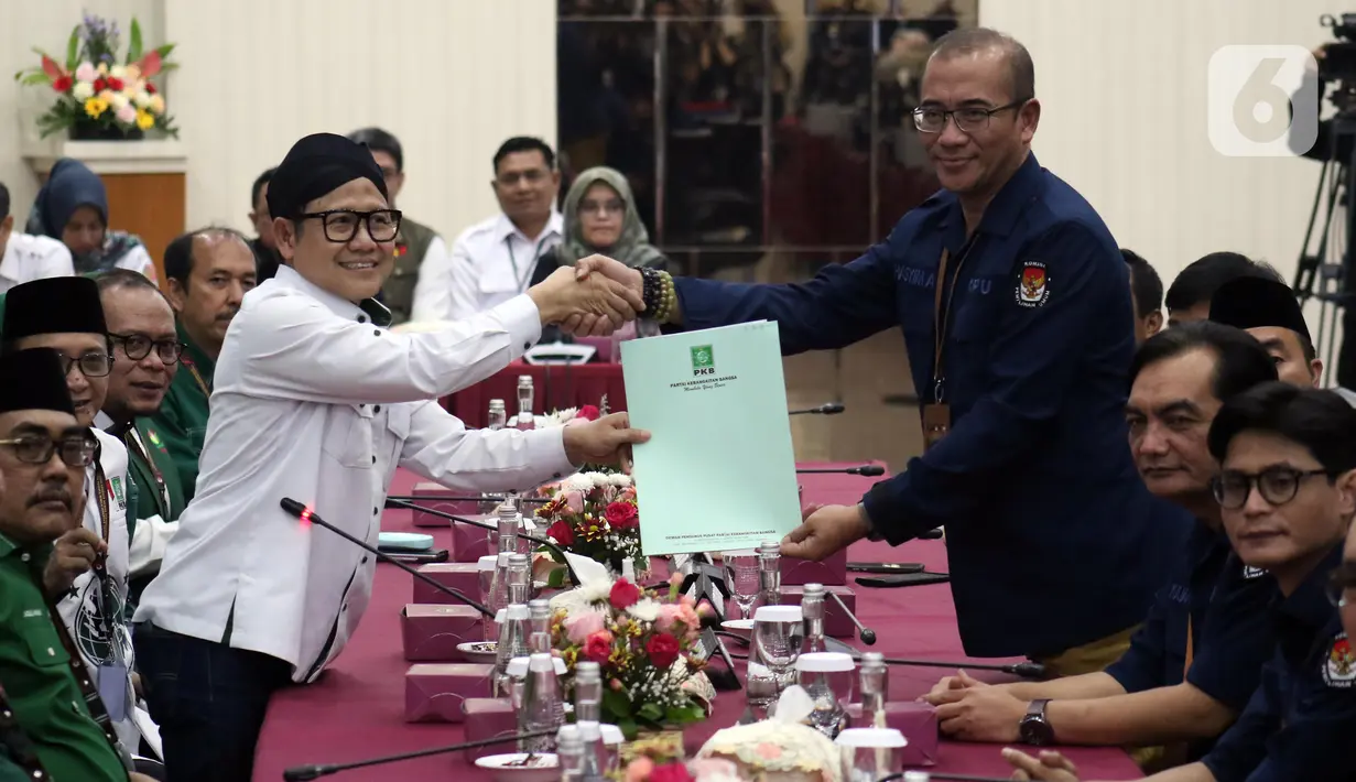 Ketua Umum Partai Kebangkitan Bangsa (PKB), Muhaimin Iskandar (kiri berdiri) menyerahkan berkas Bakal Calon Legislatif (Bacaleg) kepada Ketua Komisi Pemilihan Umum (KPU) Republik Indonesia, Hasyim Asy'ari di Gedung KPU RI, Jakarta, Sabtu (13/5/2023). (Liputan6.com/Helmi Fithriansyah)