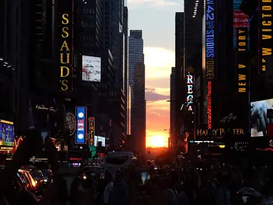 Matahari terbenam di antara pencakar langit, sejajar tepat dengan jalan, ketika fenomena Manhattanhenge di 42nd street di Times Square, New York City, Kamis (12/7). Fenomena ini hanya terjadi selama beberapa hari dalam setahun. (AFP/TIMOTHY A. CLARY)