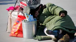 Seorang wanita tidur di dekat barang bawaannya saat menunggu keberangkatan kereta yang akan ditumpanginya di Stasiun Beijing, Selasa (2/2). Warga China sedang mempersiapkan menyambut Tahun Baru Imlek yang jatuh pada 8 Februari (Reuters/Kim Kyung-Hoon)