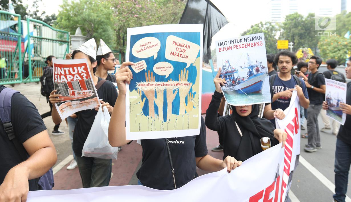 Massa yang tergabung dalam Koalisi Selamatkan Teluk Jakarta menggelar aksi jalan mundur menuju Balai Kota di Jakarta, Senin (24/6). Dalam aksinya mereka meminta kepada Gubernur DKI Jakarta untuk mencabut kembali keputusan penerbitan IMB di Pulau C dan D reklamasi Teluk Jakarta. (Liputan6.com/Angga Y