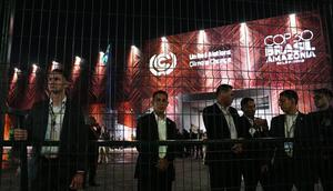 Petugas keamanan berdiri di balik pagar di luar lokasi Konferensi Tingkat Tinggi Iklim PBB (COP30) di Belem, Brasil, Selasa (11/11/2025). (Dok. AP/Joshua A. Bickel)