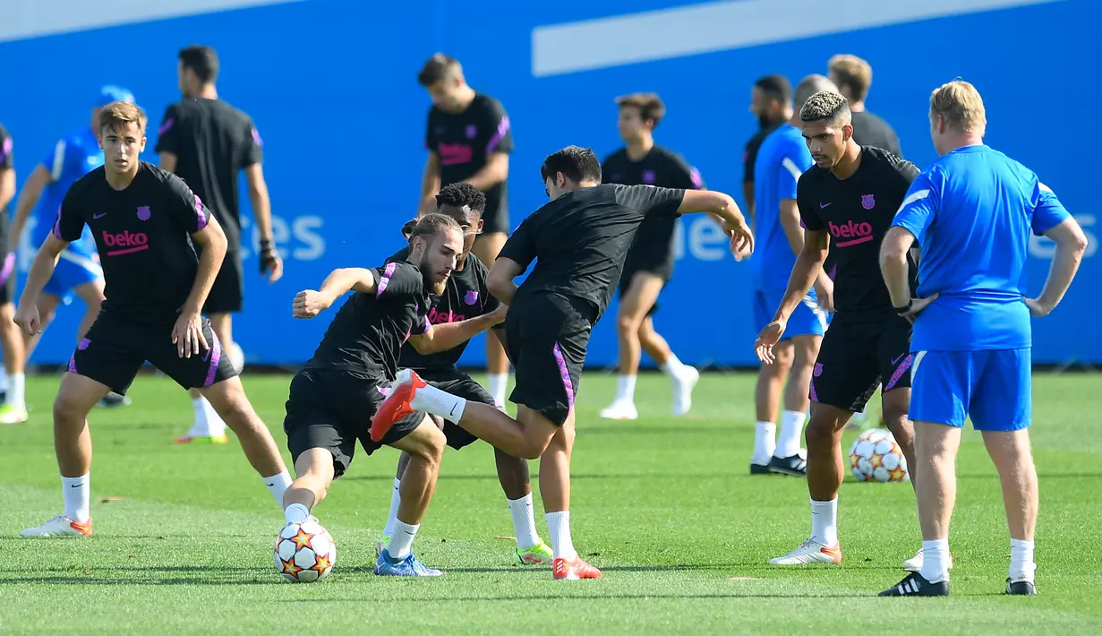 Bek Barcelona Oscar Mingueza menendang bola di sebelah rekannya Eric Garcia selama sesi latihan menjelang melawan Benfica di Joan Gamper di Sant Joan Despi, Selasa (28/9/2021). Laga Benfica vs Barcelona dalam laga fase Grup E Liga Champions digelar pada Kamis 30 September mendatang. (Josep LAGO/AFP)