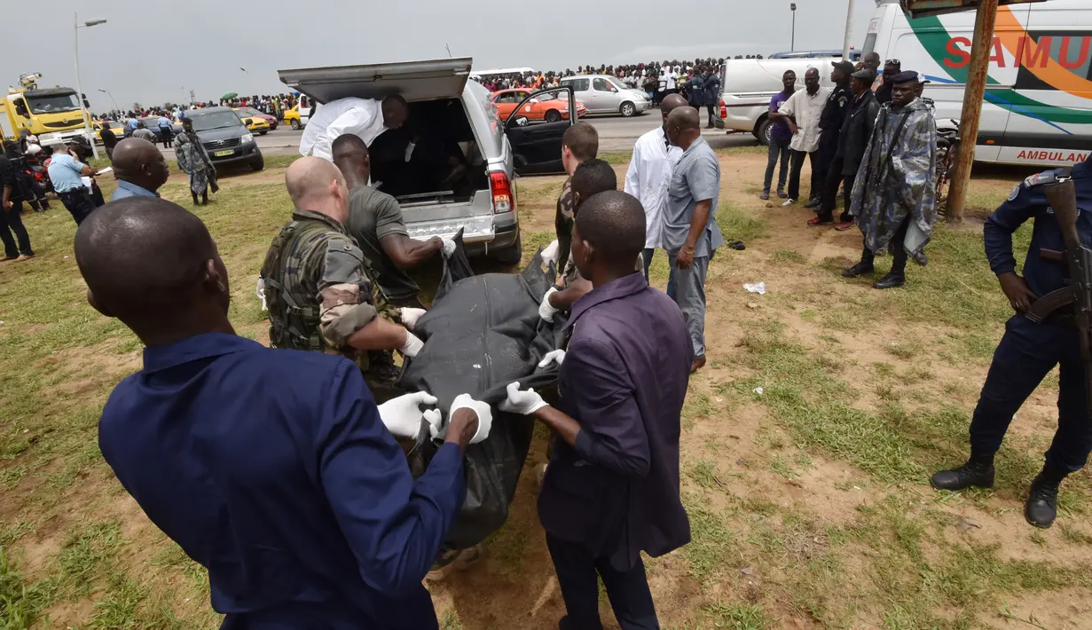 Prajurit bersama petugas mengangkut kantung jenazah dari 4 orang warga Moldovan yang tewas akibat jatuhnya pesawat kargo Antonov yang dihantam ombak besar Pantai Gading, di Abidjan (14/10). (AFP PHOTO / Sia KAMBOU)