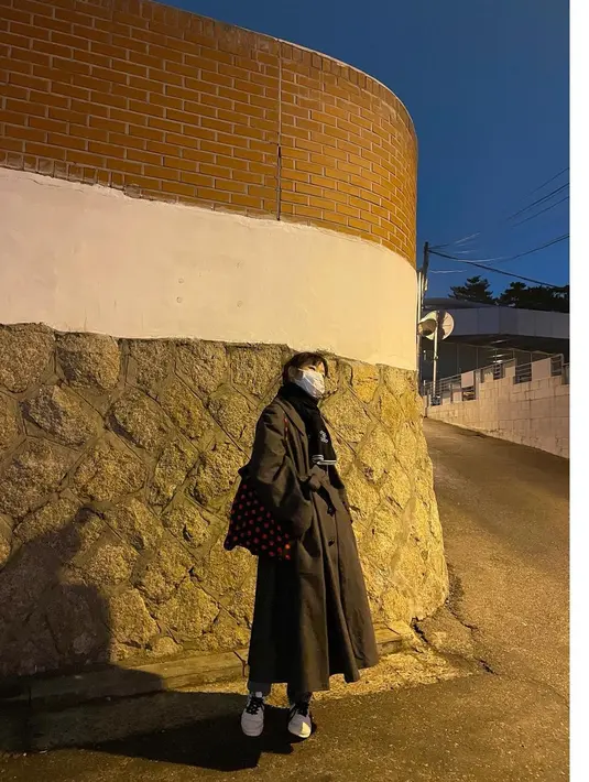 Dalam foto ini, Kim Go Eun terlihat mengenakan coat cokelat, lengkap dengan syal hitam dan masker. Kamu juga bisa menambahkan detail kasual, seperti tas dan sneakers. Foto: Instagram @ggonekim.