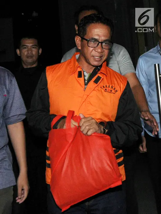 Bupati Mesuji, Khamami kenakan rompi tahanan dikawal petugas usai menjalani pemeriksaan 1x24 jam di gedung KPK, Jakarta, Jumat (25/1). Khamami terjaring OTT terkait fee suap proyek infrastruktur Kabupaten Mesuji. (merdeka.com/Dwi Narwoko)