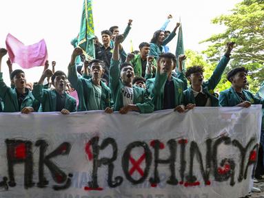 Mahasiswa memegang spanduk bertuliskan “Tolak Rohingya” saat berdemonstrasi menentang kedatangan pengungsi Rohingya di depan Dewan Perwakilan Rakyat (DPR) di Banda Aceh, Rabu (27/12/2023). Aksi diikuti oleh ratusan mahasiswa dari berbagai universitas. (CHAIDEER MAHYUDDIN/AFP)