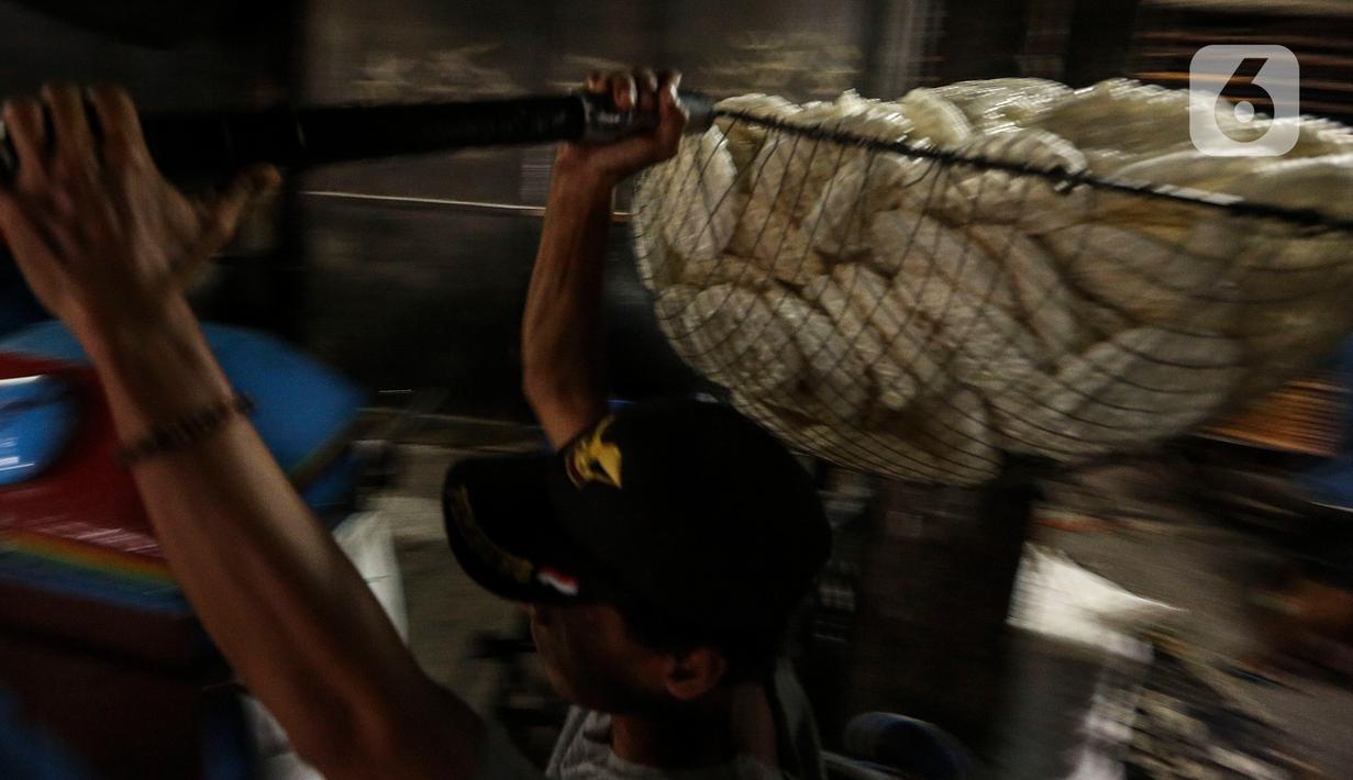 Pekerja membawa kerupuk yang telah digoreng di UKM Kerupuk Melati, Jakarta, Rabu (16/12/2020). Pada masa pandemi COVID-19, UKM tersebut memproduksi kerupuk kurang lebih dua kuintal per hari atau menurun 40 persen dari kondisi normal. (Liputan6.com/Johan Tallo)