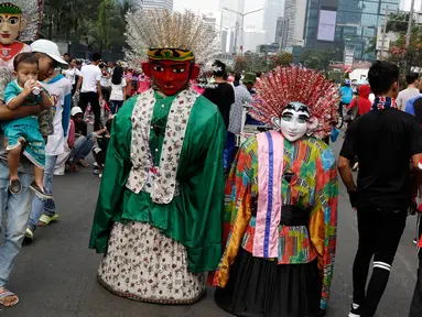 Pengamen ondel-ondel meminta sumbangan kepada warga di lokasi car free day, Jakarta, Minggu (21/5). Ramainya pengunjung CFD menyebabkan banyak pengamen mencari rezeki di kegiatan yang berlangsung setiap minggu tersebut. (Liputan6.com/Immanuel Antonius)