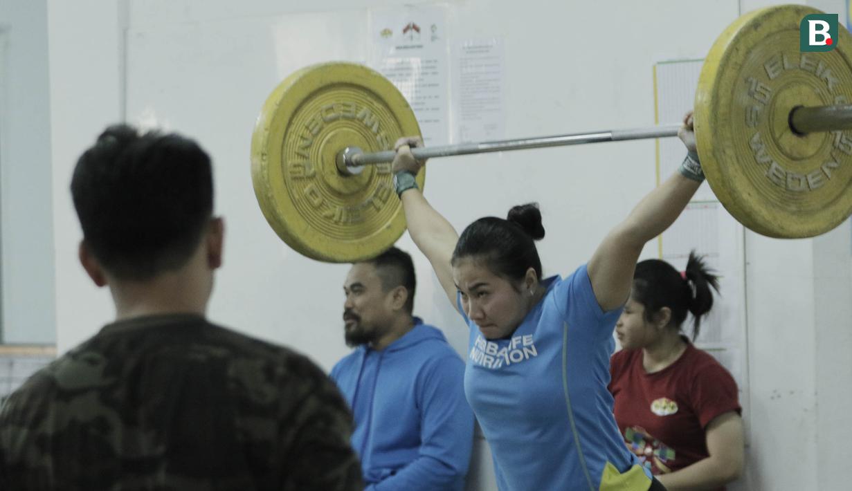 Atlet angkat besi, Dewi Safitri, saat latihan di Wisma Kwini, Jakarta, Senin, (12/6/2018). Para lifter perempuan Indonesia terus melakukan persiapan jelang Asiang Games 2018. (Bola.com/M Iqbal Ichsan)