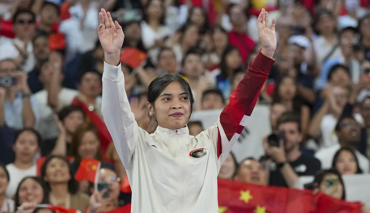 <p>Pebulu tangkis Indonesia, Gregoria Mariska Tunjung memberi aplaus kepada penonton dari atas podium untuk menerima pengalungan medali perunggu nomor tunggal putri cabor bulu tangkis Olimpiade Paris 2024 saat upacara penyerahan medali di Porte de La Chapelle Arena, Paris, Senin (5/8/2024). (AP Photo/Kin Cheung)</p>