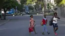 Orang-orang berjalan melewati kendaraan militer yang menghalangi pintu masuk ke Petion Ville, lingkungan tempat mendiang Presiden Haiti Jovenel Moise tinggal di Port-au-Prince, Haiti, Rabu (7/7/2021).  (AP Photo/Joseph Odelyn)