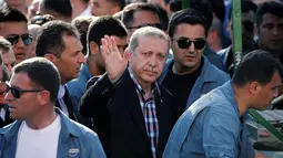 Presiden Turki, Recep Tayyip Erdogan menyapa warga saat upacara pemakaman korban upaya kudeta militer yang dilakukan terhadapnya, di Istanbul, Minggu (17/7). Kudeta militer Turki pada Jumat kemarin menewaskan 265 orang. (REUTERS/Alkis Konstantinidis)