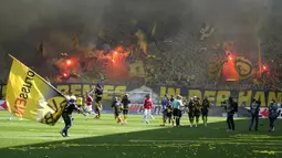 Para suporter menyalakan flare sebelum dimulainya laga pekan terakhir terakhir Liga Jerman 2022/2023 antara Borussia Dortmund menghadapi FSV Mainz di Dortmund, Jerman (27/5/2023). (AP Photo/Michael Probst)