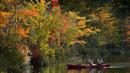 Seorang penumpang di kano memotret dedaunan musim gugur yang indah di South Pond, Bryant Point, Maine, Amerika Serikat pada 9 Oktober 2021. Daun musim gugur mencapai warna puncak di sebagian besar negara bagian. (AP Photo/Robert F. Bukaty)