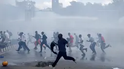 Pengunjuk rasa berlari menghindari gas air mata yang disemprotkan petugas saat bentrok di Nairobi, Kenya (16/5/2016). Mereka menuntut pembubaran otoritas pemilu karena adanya dugaan korupsi. (REUTERS/Goran Tomasevic)