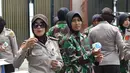 Sejumlah polwan memberikan minuman kepada pengunjuk rasa saat Aksi Damai 4 November di Jakarta, Jumat (4/11). Hampir semua polwan yang berjaga dalam aksi ini mengenakan hijab. (Twitter.com@TMCPoldaMetro)