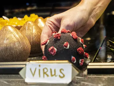 Seorang pramusaji mengambil makanan penutup berbentuk virus corona Covid-19 di sebuah kafe di Praha pada 06 Oktober 2020. Dengan lebih dari 81.000 kasus di Republik Ceko, tingkat penyebaran Covid-19 termasuk yang terburuk di Eropa - hampir separah di Spanyol. (Michal Cizek / AFP)
