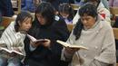 Calon ibu negara Peru, Lilia Paredes (48) membaca Alkitab sambil duduk di sebelah adiknya Yenifer dan sang putri Alondra (9) selama kebaktian gereja di mana para tetangga diundang untuk mengucapkan selamat tinggal sebelum keberangkatan keluarga ke Lima, di Chugur, 22 Juli 2021. (AP/Franklin Briceno)