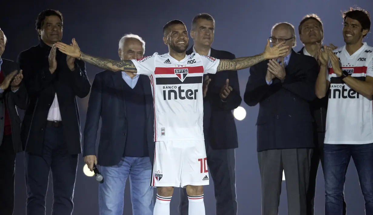 Bek Dani Alves menyapa para suporter saat diperkenalkan sebagai bek baru Sao Paulo di stadion Morumbi, Brasil (6/8/2019). Dani Alves memulai karirnya dari Bahia, klub kota kelahirannya lalu hijrah ke Eropa membelaw Sevilla, Barcelona dan PSG. (AP Photo/Andre Penner)